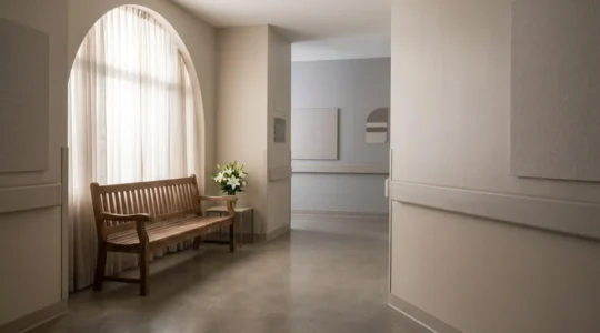 Couloir calme et lumineux d'un espace de recueillement funéraire dans un établissement de santé français