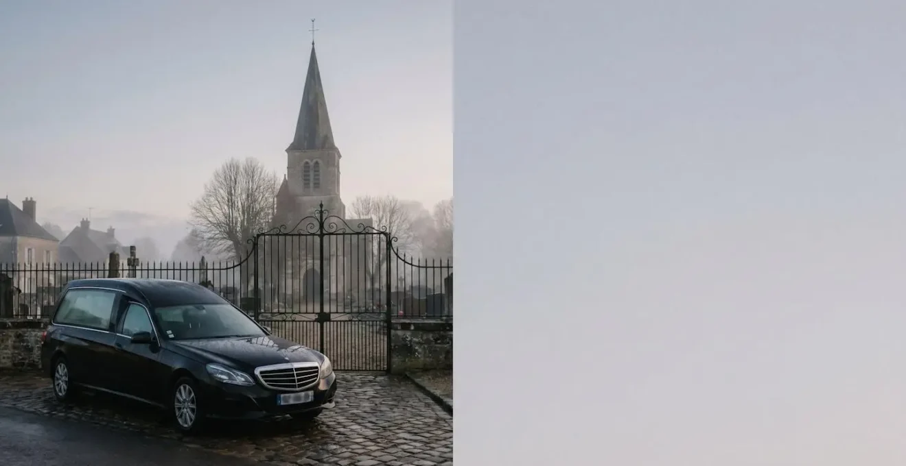 Corbillard noir stationné discrètement devant le portail en fer forgé d'un cimetière de village français, dans la brume matinale, illustrant l'organisation du transport funéraire.