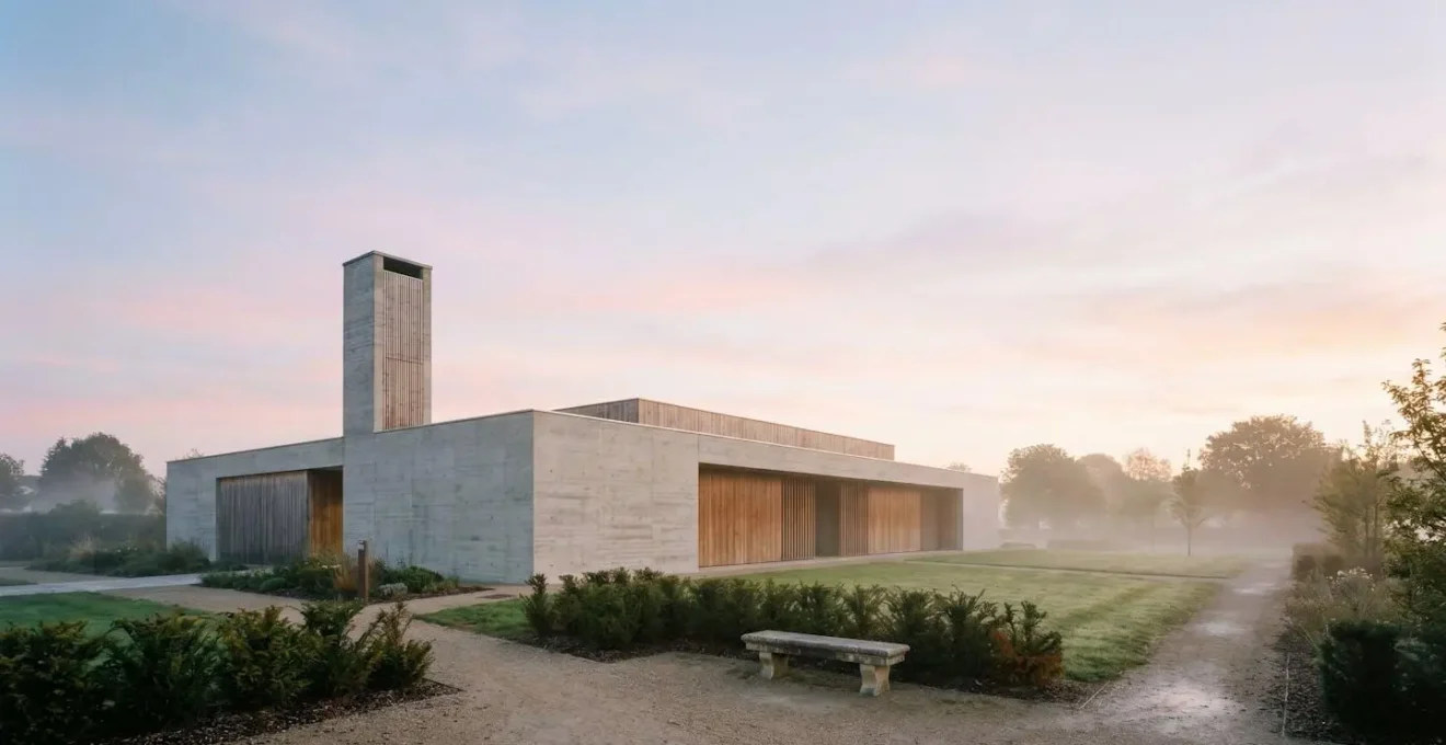 Crématorium français moderne entouré d'un jardin du souvenir au petit matin, illustrant le lieu où se déroule la crémation