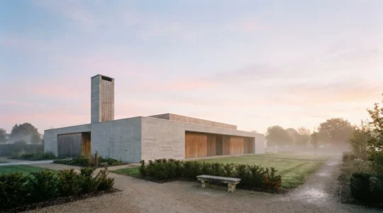 Crématorium français moderne entouré d'un jardin du souvenir au petit matin, illustrant le lieu où se déroule la crémation